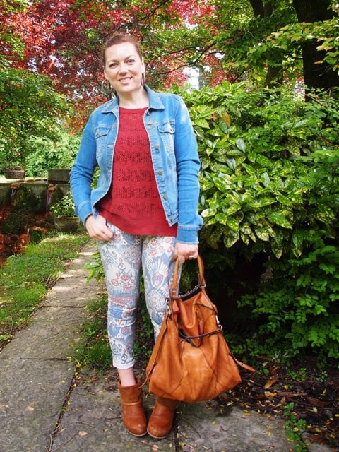 outfit stile tex-mex con giacchina in denim, jeans stampati, stivali e borsa in cuoio outfit stile tex-mex con giacchina in denim, jeans stampati, stivali e borsa in cuoio