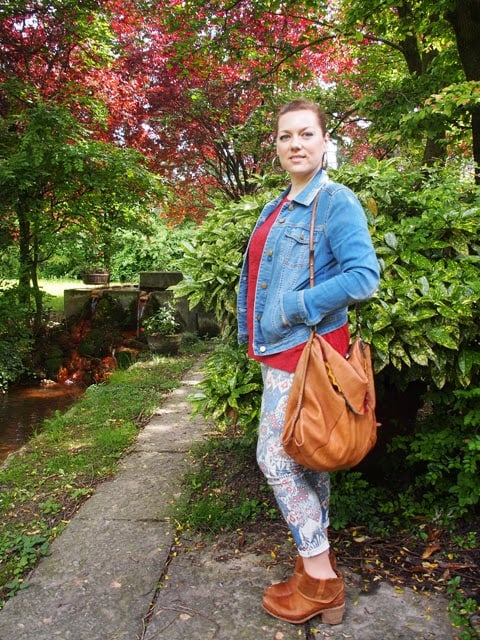 outfit stile tex-mex con giacchina in denim, jeans stampati, stivali e borsa in cuoio outfit stile tex-mex con giacchina in denim, jeans stampati, stivali e borsa in cuoio